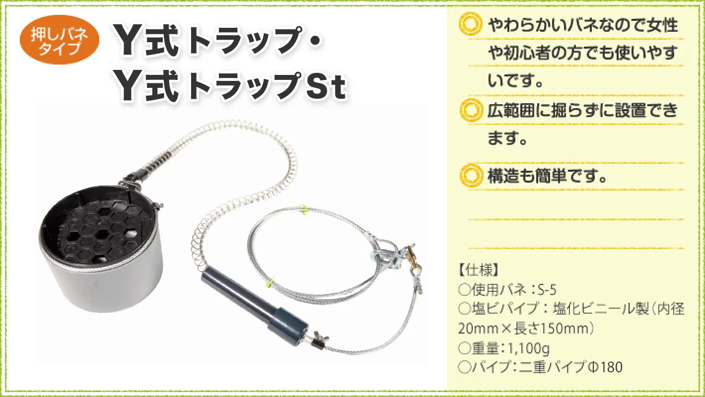 押しバネタイプの「Y式トラップ・Y式トラップSt」を紹介する商品画像。左側に円筒形の本体、ワイヤー、バネ付き部品を配置し、右側に「やわらかいバネで女性や初心者にも使いやすい」「広範囲に掘らず設置できる」「構造が簡単」と特徴を記載。仕様は使用バネS-5、塩ビパイプ内径20mm・長さ150mm、重量1,100g、二重パイプΦ180。